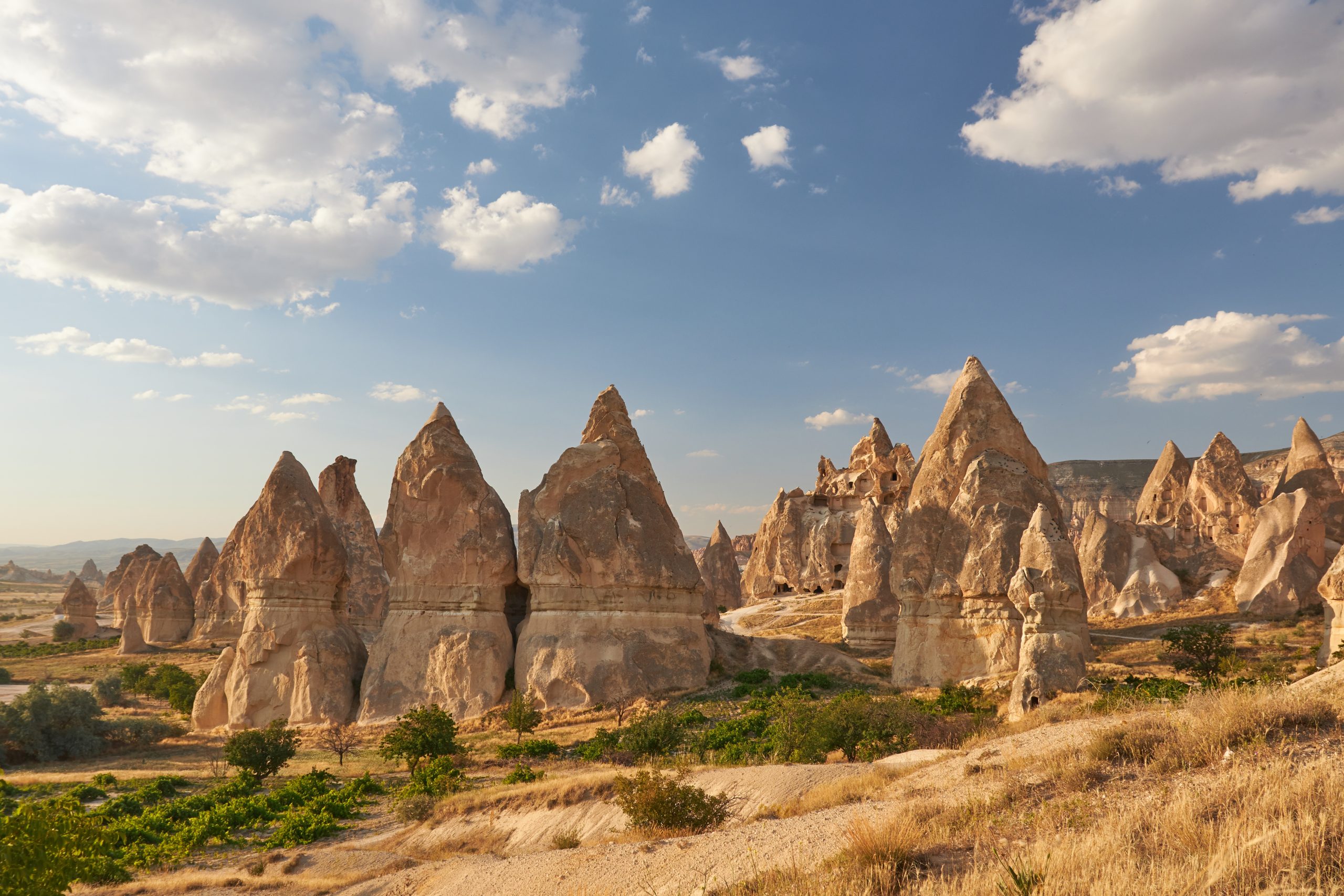 a rocky landscape with tall rocks with Cappadocia in the background